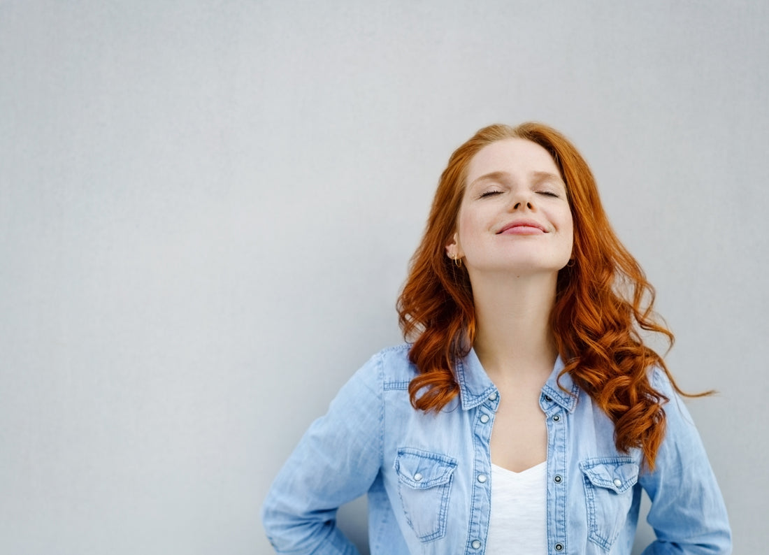 content_women_leaning_against_a_wall_eyes_closed_breathing