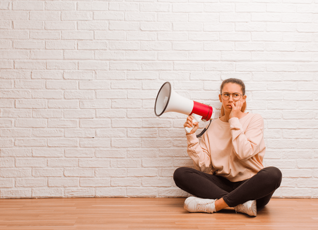 Young_lady_sitting_on_floor_holding_megaphone