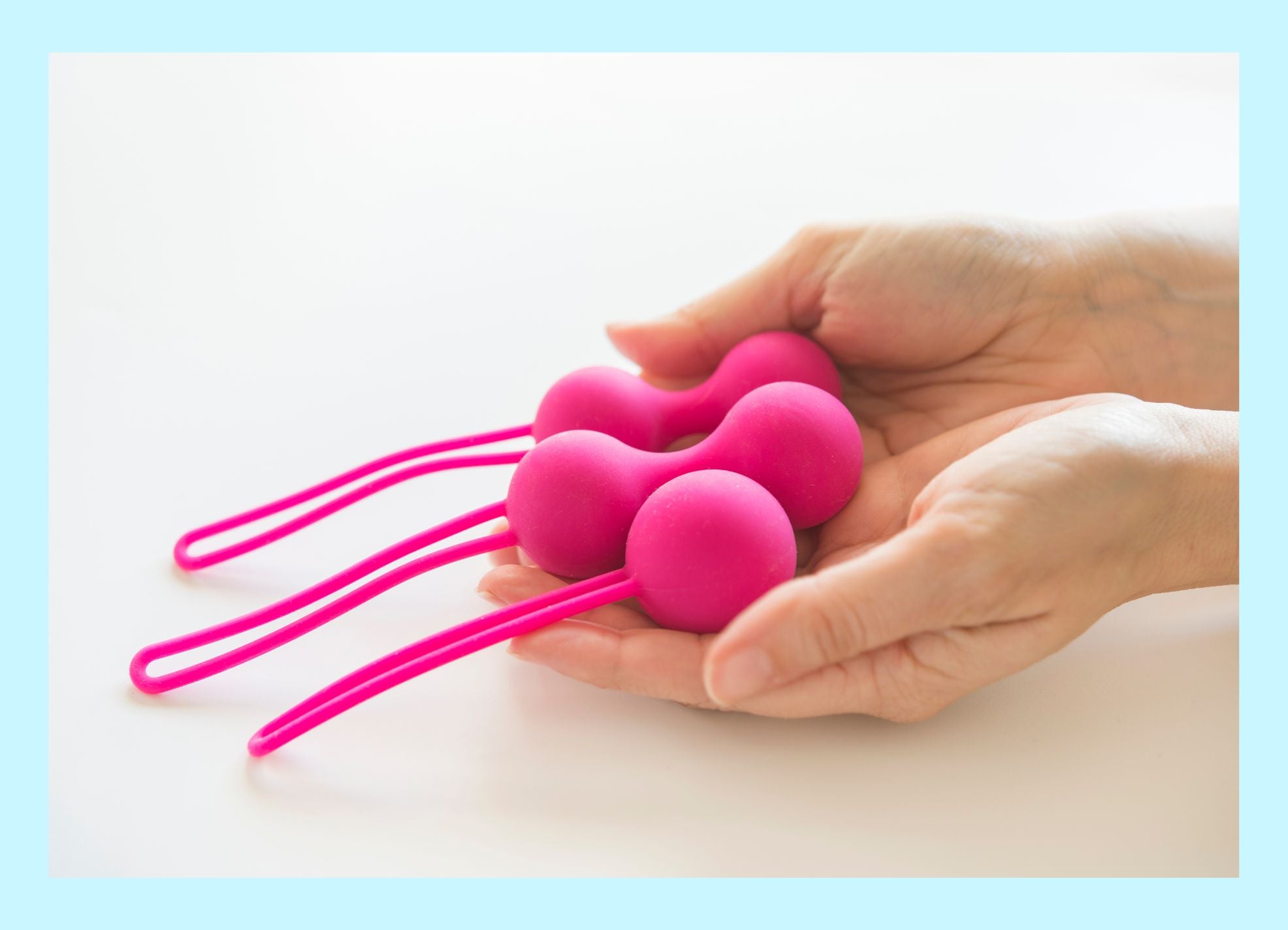Pair of pink Kegel balls held in hands